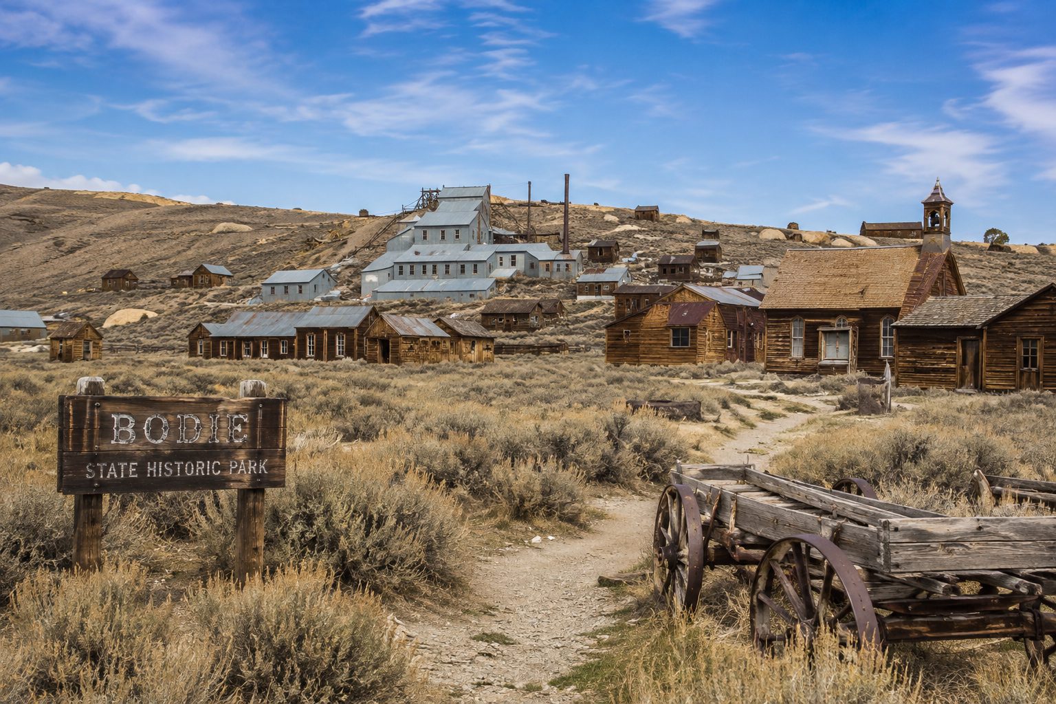 Weathered wooden storefronts line the empty main street of an abandoned American mining town, Bodie